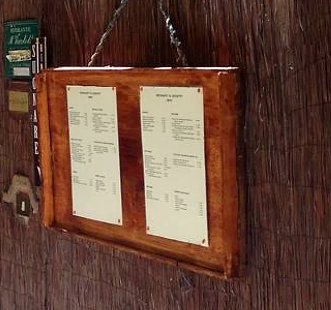 Il menu del giorno, due fogli dattiloscritti in una cornice di legno appesa al canniccio accanto alla porta